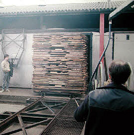 Photo showing a stack of timber being moved into a kiln.